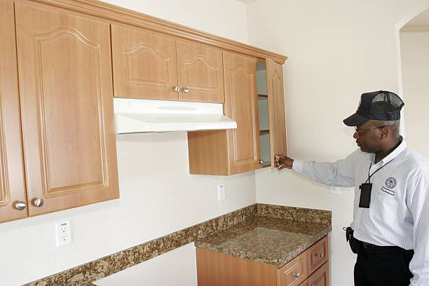 Exterminator inspecting kitchen